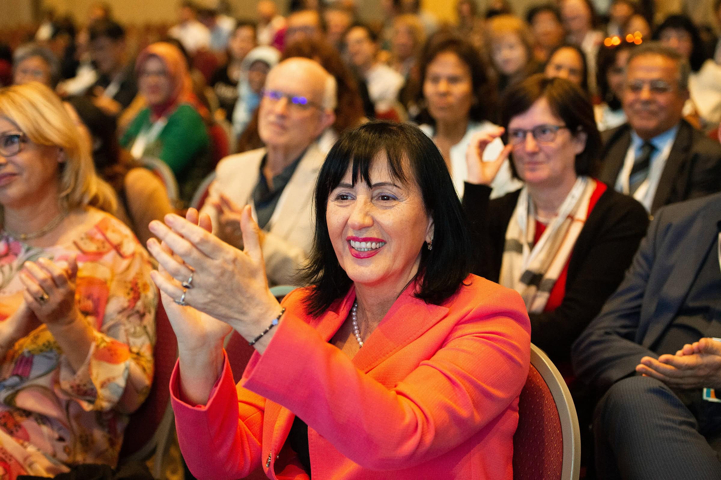 A woman clapping at a conference